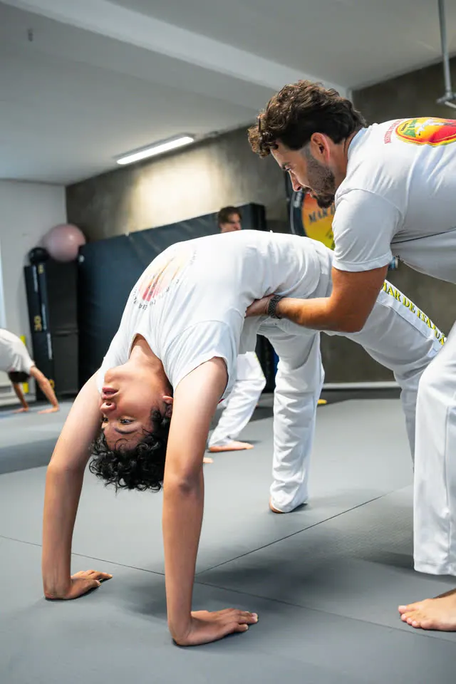 Capoeira-Training: Trainer hilft bei der Brücke