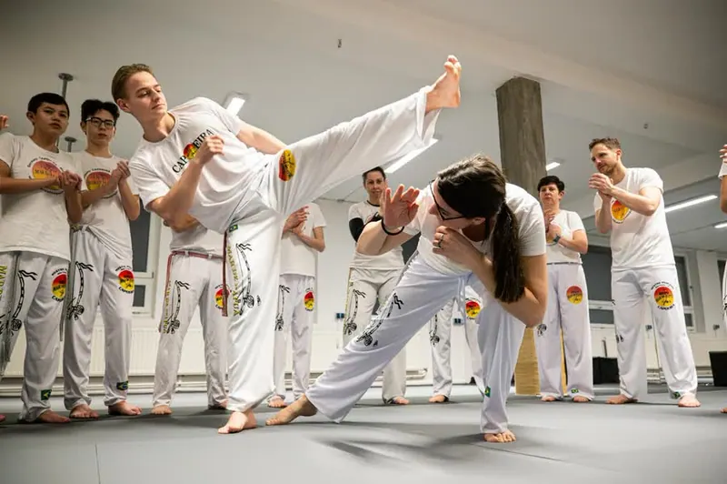 Capoeira für Kinder: Jugendliche beim Tritt in der Roda