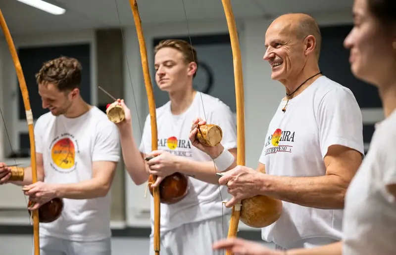 Alunos tocando berimbau na Munich Capoeira